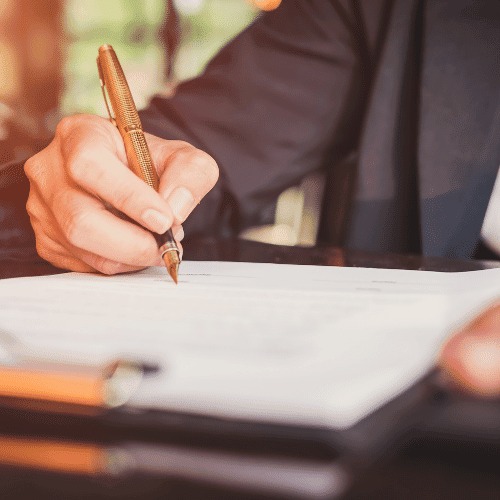 Man holding golden fountain pen signing a Supervised work permit document.