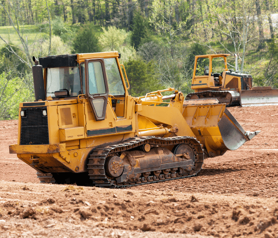 Dozer Ticket Perth / Bulldozer Licence Perth - Dozer in Operation. Conduct Civil Construction Dozer Operations. Two yellow bulldozers operating on a construction site with greenery in the background